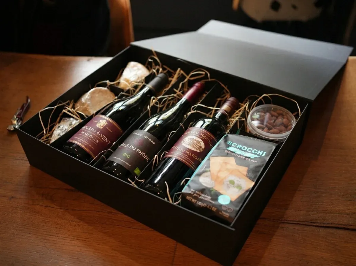 Inhoud van een relatiegeschenk met wijn en kaas: drie wijnen, kaas, luxe toastjes en noten