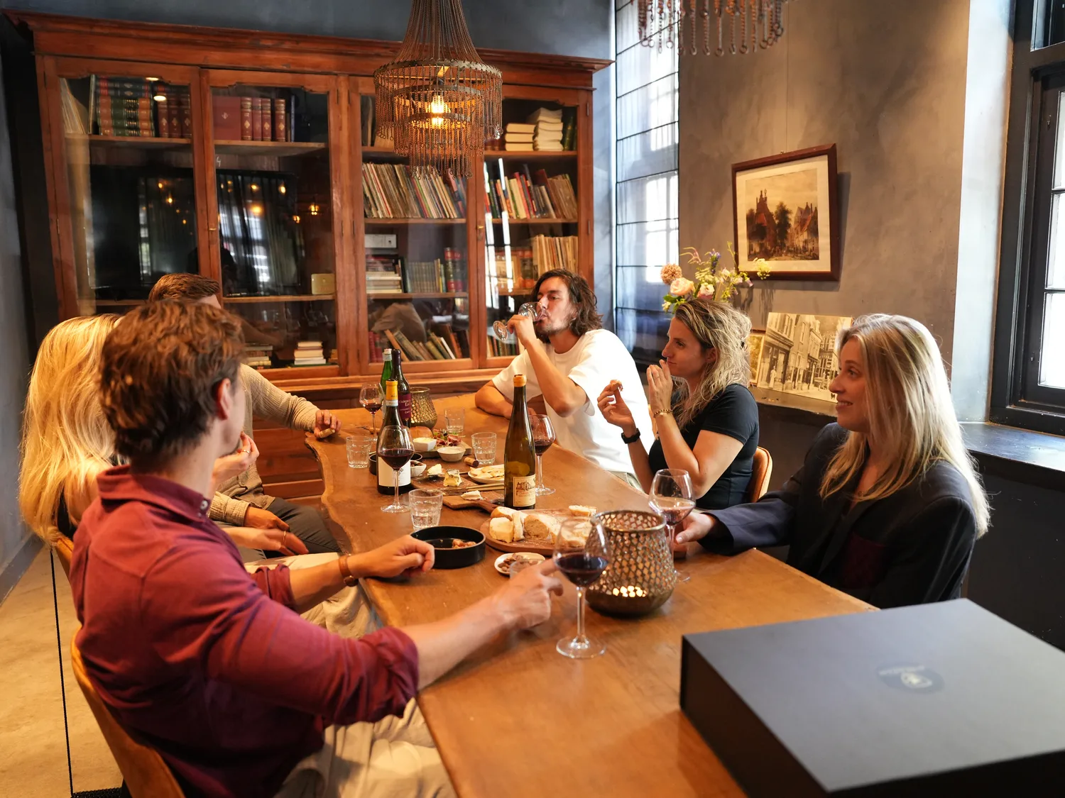 Deelnemers heffen het glas tijdens een wijn- en kaasproeverij
