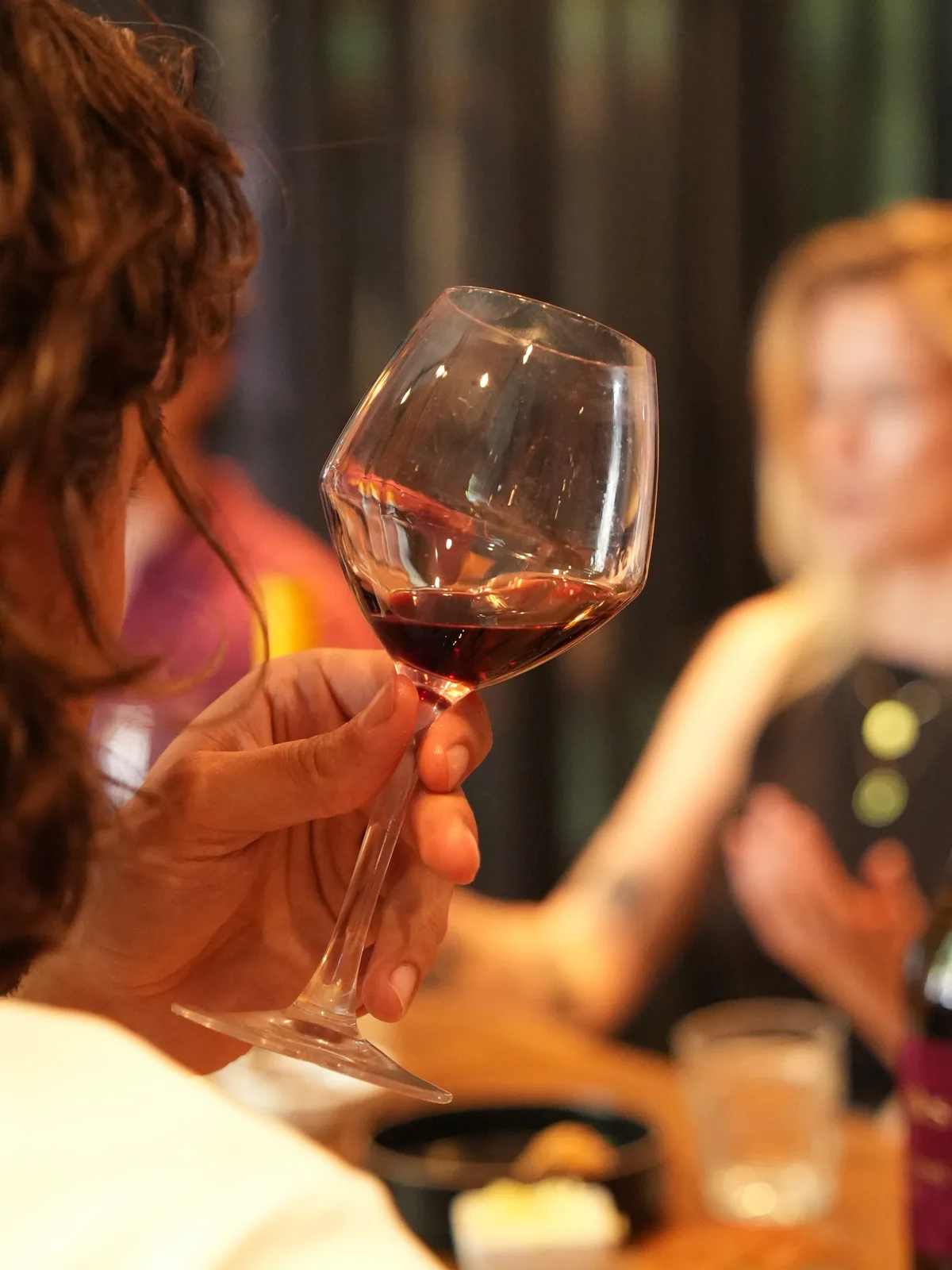 Een deelnemer ruikt aan een glas rode wijn tijdens een wijnproeverij